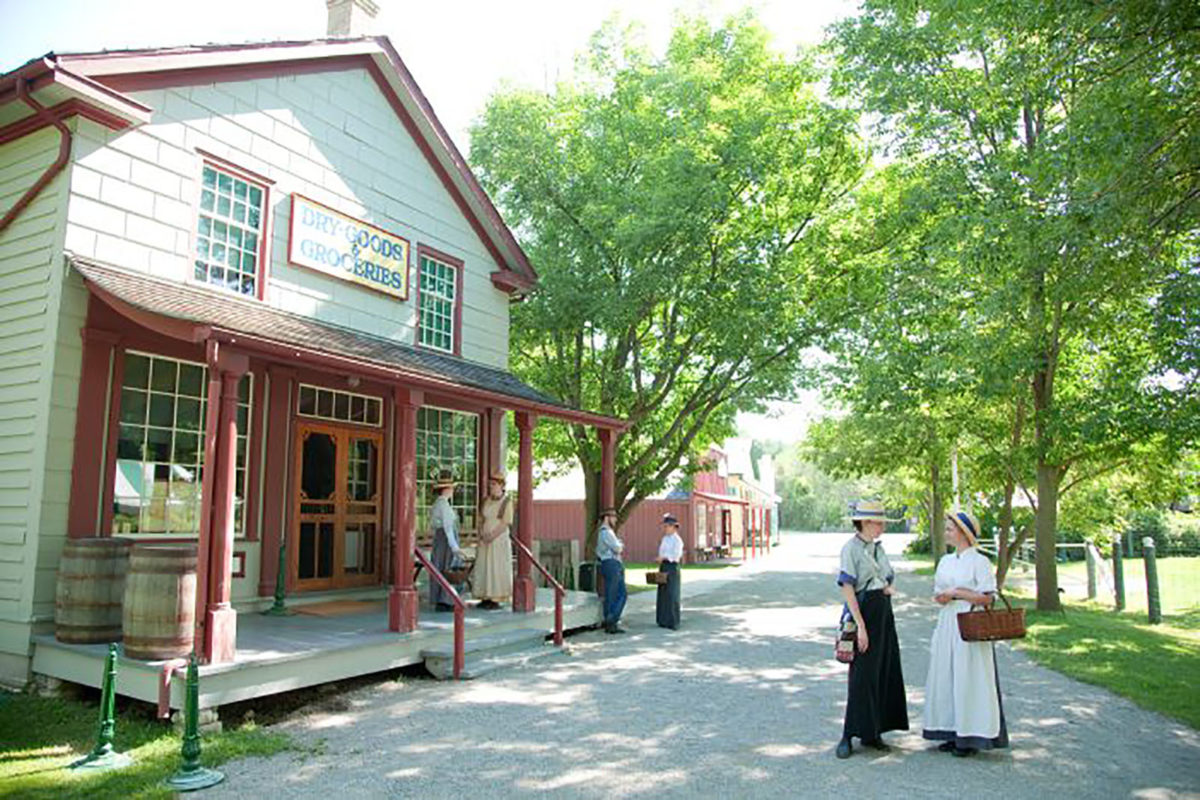 Costumed interpreters wandering through the historic 1914 village that is Doon Heritage Village on a sunny summer's day. 