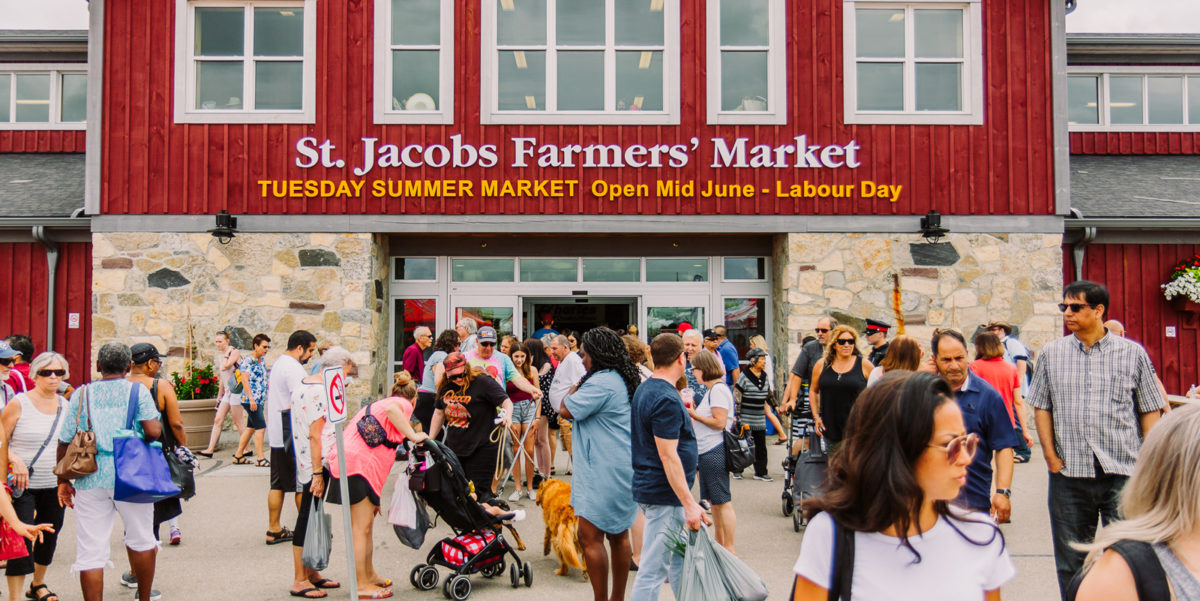 Visitors walking in front of the St. Jacobs Farmers' Market main building in St. Jacobs