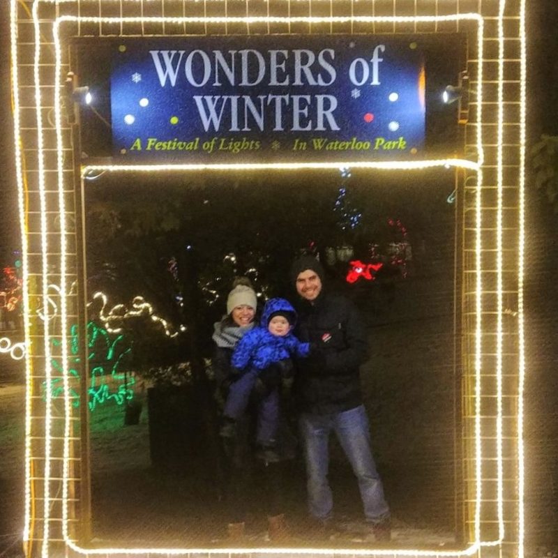 Two people standing underneath the entrance to the lights display at Wonders of Winter in Waterloo Park