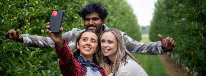 Friends taking selfie in apple orchard