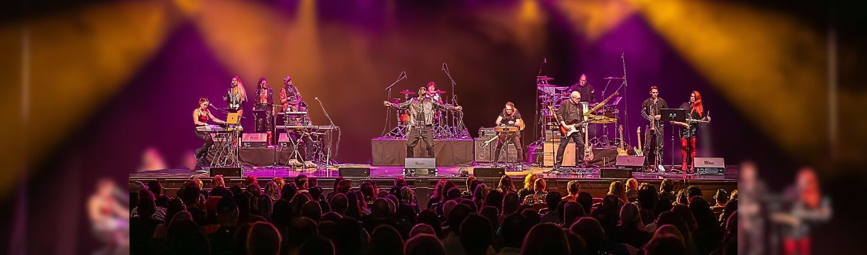 A large band performing on the main stage at Centre In The Square in Kitchener. There appears to be a large audience taking in the performance.