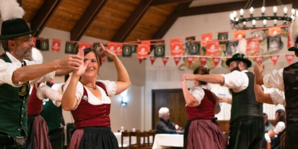 Dancers in traditional Bavarian costumes dance in a small fest hall as part of the Kitchener Waterloo Oktoberfest celebrations.