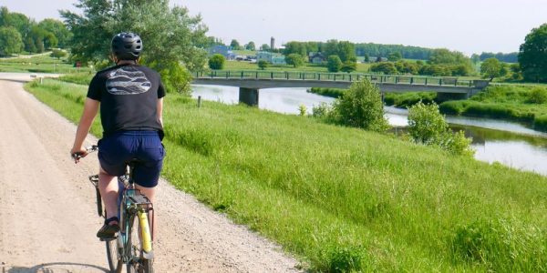 A cyclist riding along Temperence Road in Woolwich Township near St. Jacobs on a sunny summer's day. The gravel road runs along the Conestogo River.