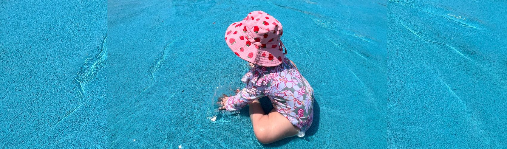 A toddler in the shallow water at the spray pad at Bingemans on a sunny summer's day