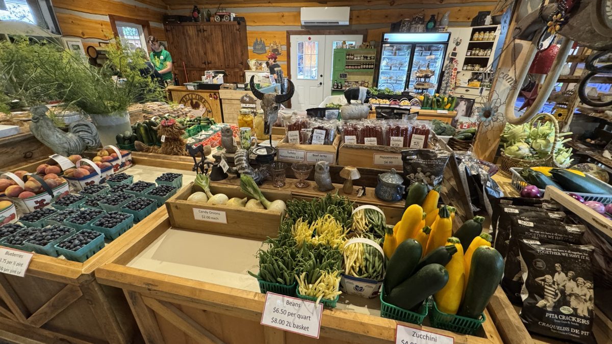 The interior of Fall Harvest Farm in Wellesley. There are displays of fresh produce, preserves and stand up refrigerators filled with perishable food items