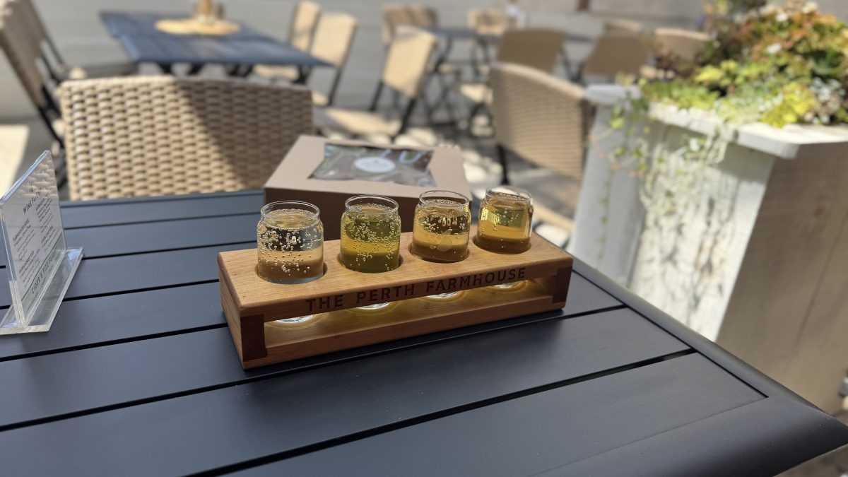 A cider flight on a picnic table on the patio at The Perth Farmhouse - Wine & Cider