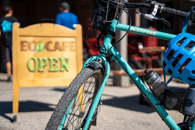 A blue bicycle propped up by a sign that says EcoCafe in St. Jacobs.