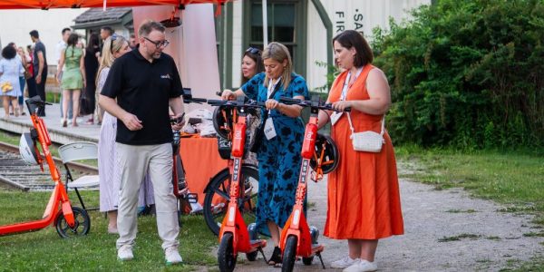 Three people trying out the Neuron Mobility electric scooters at the CSAE conference in Waterloo Region.