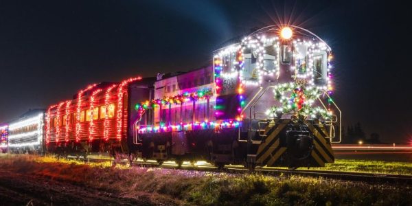 A Waterloo Central Railway holiday train all lit up and travelling along the tracks at night