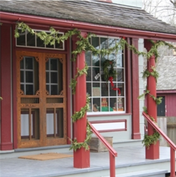 The door of the post office building at Doon Heritage Village, decorated for the holidays with ribbons and greenery.