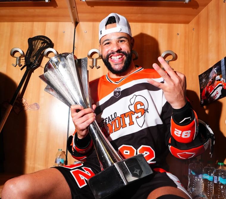 Lacrosse player Dhane Smith with the National Lacrosse League championships trophy as part of the Buffalo Bandits.
