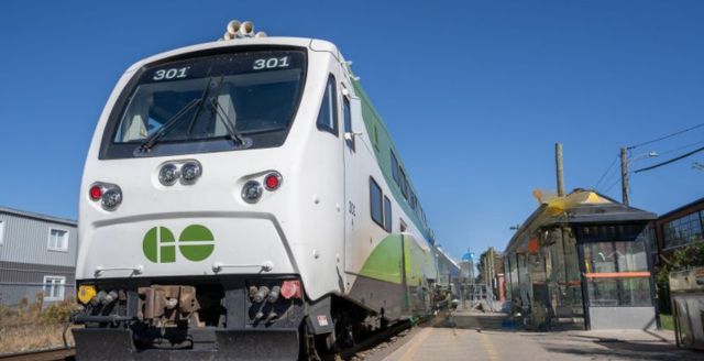 A green and white GO Train arriving at the Kitchener train station.