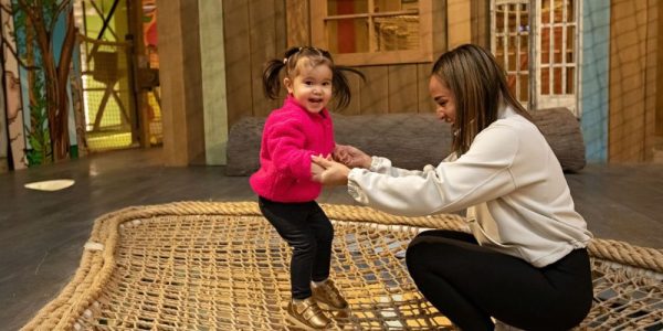 A parent and child playing on a mesh trampoline area at THEMUSEUM in Kitchener