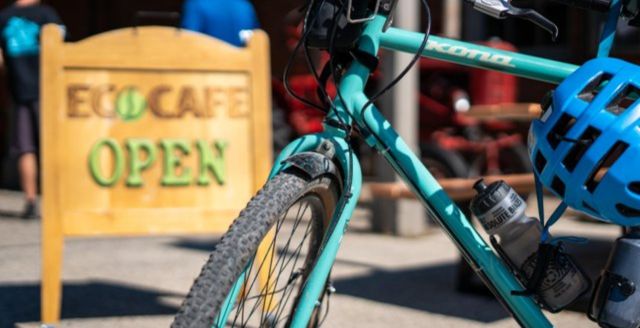 A blue bicycle propped up by a sign that says EcoCafe in St. Jacobs.