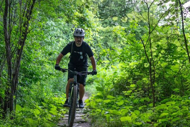 A cyclist cycling along one of the trail on the Hydrocut in Waterloo Region on a sunny day