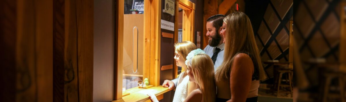 A smiling family at the box office window presumably picking up tickets to a show at the St. Jacobs Country Playhouse.