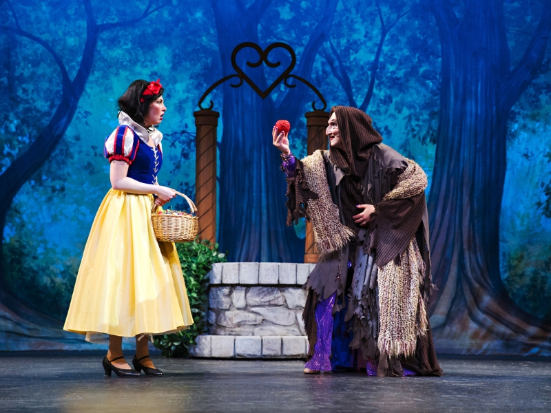 A performance shot from Drayton's Entertainment holiday performance of Snow White and the Seven Tenors: A Panto. The shot is of Snow White encountering the evil witch, who is offering her an apple.